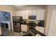 A bright kitchen featuring stainless steel appliances, black countertops, and white cabinets with matte black hardware at 1250 Parkwood Cir # 2112, Atlanta, GA 30339