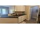 A well-lit kitchen boasts black countertops, white cabinets, and a stainless steel sink next to an opening to another room at 1250 Parkwood Cir # 2112, Atlanta, GA 30339
