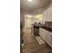 Modern kitchen with stainless steel appliances, light wood-look flooring, white cabinets, and dark countertops at 1250 Parkwood Cir # 2112, Atlanta, GA 30339