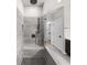 Modern shower with gray tiling and a built in bench, inside of a renovated bathroom at 219 Phillips Ln, Alpharetta, GA 30009