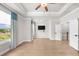 Large primary bedroom featuring a tray ceiling, ceiling fan, and two entry doors at 219 Phillips Ln, Alpharetta, GA 30009