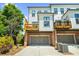 View of two-story townhomes showcasing a garage and a wooden deck overlooking a driveway at 219 Phillips Ln, Alpharetta, GA 30009