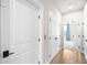 Hallway with wood floors, white doors, and dark hardware, plus a view into another room at 219 Phillips Ln, Alpharetta, GA 30009
