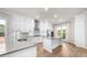 Modern kitchen boasts white cabinets, stainless steel appliances, an island, and an open layout to the living area at 219 Phillips Ln, Alpharetta, GA 30009