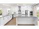 The contemporary kitchen features white cabinets, stainless steel appliances, and a central island at 219 Phillips Ln, Alpharetta, GA 30009