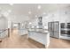 Bright, open-concept kitchen featuring stainless steel appliances, white cabinetry, a center island, and hardwood flooring at 219 Phillips Ln, Alpharetta, GA 30009