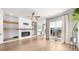 Bright living room with hardwood floors, a modern fireplace, built-in shelving, and large windows with elegant curtains at 219 Phillips Ln, Alpharetta, GA 30009