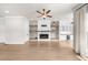 Open living room with hardwood floors, a cozy fireplace, custom built-ins, and abundant natural light from large windows at 219 Phillips Ln, Alpharetta, GA 30009