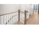 Staircase landing with light hardwood flooring and traditional wood and white railing at 219 Phillips Ln, Alpharetta, GA 30009
