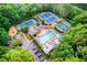 Aerial view of community amenities: tennis courts, swimming pool, clubhouse, parking, and green landscaping at 5010 Bonnie Way, Roswell, GA 30075