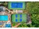 Aerial view featuring tennis courts, swimming pool, pickle ball courts, and lush landscaping in community at 5010 Bonnie Way, Roswell, GA 30075