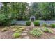 Serene backyard garden with a white picket fence, arbor, and stone pathway among lush landscaping at 5010 Bonnie Way, Roswell, GA 30075