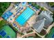Aerial view of a community swimming pool with lounge chairs and umbrellas, plus clubhouse and tennis courts at 5010 Bonnie Way, Roswell, GA 30075