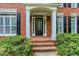 Elegant entrance with a black front door, white columns, and brick steps at 5010 Bonnie Way, Roswell, GA 30075