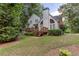 Rear exterior view of home with large windows, deck, and well-manicured lawn at 5010 Bonnie Way, Roswell, GA 30075