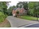 Traditional brick home with well-manicured landscaping, a curved driveway, and a welcoming front porch at 5010 Bonnie Way, Roswell, GA 30075