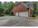 Spacious three-car garage with a large driveway and brick exterior at 5010 Bonnie Way, Roswell, GA 30075