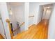 Bright hallway with hardwood floors, white walls, stairs, and a decorative light fixture at 5010 Bonnie Way, Roswell, GA 30075