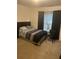 This bedroom features a queen bed, curtains, neutral carpet, and a comfy chair for relaxing after a long day at 947 Simonton View Ln, Lawrenceville, GA 30045