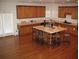 Spacious eat-in kitchen with wood cabinets, matching island, and hardwood floors at 947 Simonton View Ln, Lawrenceville, GA 30045