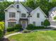 Charming two-story home with a well-manicured lawn, mature trees, and painted brick exterior at 103 Caracas Dr, Woodstock, GA 30188