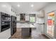 Modern kitchen with white cabinets, gray island, stainless steel appliances, and hardwood flooring at 103 Caracas Dr, Woodstock, GA 30188
