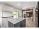 Open-concept kitchen featuring a center island, white cabinets, hardwood floors, and a view to the living area at 103 Caracas Dr, Woodstock, GA 30188