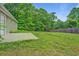 Backyard featuring a concrete patio, lawn, and bordering trees at 126 Usher Ln, Covington, GA 30016