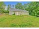 Backyard showcasing a well-maintained lawn, bordering trees, and the home's exterior at 126 Usher Ln, Covington, GA 30016