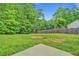 A partially-fenced backyard with a large grassy area bordered by mature trees at 126 Usher Ln, Covington, GA 30016