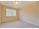 Bedroom with neutral-colored walls and plush carpeting, with a window for natural light at 126 Usher Ln, Covington, GA 30016