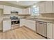 Bright kitchen featuring white cabinets, stainless steel appliances, and modern wood-style floors at 126 Usher Ln, Covington, GA 30016
