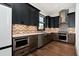 Modern kitchen with custom cabinets, chevron backsplash, stainless steel appliances, and hardwood floors at 320 Dodd Ln, Alpharetta, GA 30005