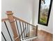 A well-lit staircase with wood railing and black iron spindles leads to the upper level at 320 Dodd Ln, Alpharetta, GA 30005