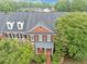 Aerial view of a brick townhome with a landscaped front yard and a private entrance at 5000 Davenport Pl, Roswell, GA 30075