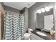 Well-lit bathroom featuring a shower with stylish curtain and a granite countertop sink at 5000 Davenport Pl, Roswell, GA 30075