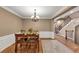 Dining room with hardwood floors, wainscoting, elegant chandelier, and staircase at 5000 Davenport Pl, Roswell, GA 30075