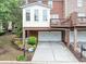 Townhome with a drive-under garage, a second story deck, and manicured landscaping at 5000 Davenport Pl, Roswell, GA 30075
