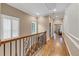 Upstairs hallway with hardwood floors, decorative railing, trim and natural light creating an elegant and welcoming space at 5000 Davenport Pl, Roswell, GA 30075