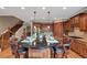 Open kitchen featuring a granite island with seating, wood cabinets, and a view of the staircase at 5000 Davenport Pl, Roswell, GA 30075