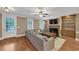 Living room featuring hardwood floors, fireplace, built-in cabinets, and a large sectional sofa at 5000 Davenport Pl, Roswell, GA 30075