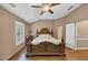 A main bedroom with ceiling fan, plantation shutters, and wood floors at 5000 Davenport Pl, Roswell, GA 30075