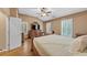 Main bedroom with a ceiling fan, plantation shutters, and hard wood floors at 5000 Davenport Pl, Roswell, GA 30075