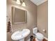 Elegant powder room with pedestal sink, decorative mirror, and classic fixtures offering a touch of sophistication at 5000 Davenport Pl, Roswell, GA 30075
