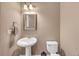 Well-lit powder room featuring a pedestal sink, neutral color palette, and convenient towel rack, perfect for guests at 5000 Davenport Pl, Roswell, GA 30075