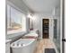 Relaxing bathroom with soaking tub, glass shower, and a view of the outdoors at 1721 Mcgarity Rd, Temple, GA 30179