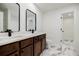 Modern bathroom with double sinks, dark wood cabinets, and tile floors at 180 Oliver Dr, Locust Grove, GA 30248