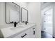 Bright bathroom with double sink, white cabinets, and black fixtures at 180 Oliver Dr, Locust Grove, GA 30248