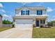 Charming two-story home featuring a two-car garage, brick accents, and a well-manicured lawn at 180 Oliver Dr, Locust Grove, GA 30248