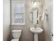 Traditional half bathroom featuring a pedestal sink, updated fixtures, oval mirror, and natural light at 2149 Shoop Se Ct # 3, Smyrna, GA 30080